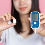 World diabetes day; woman holding Glucose meter and sugar cubes